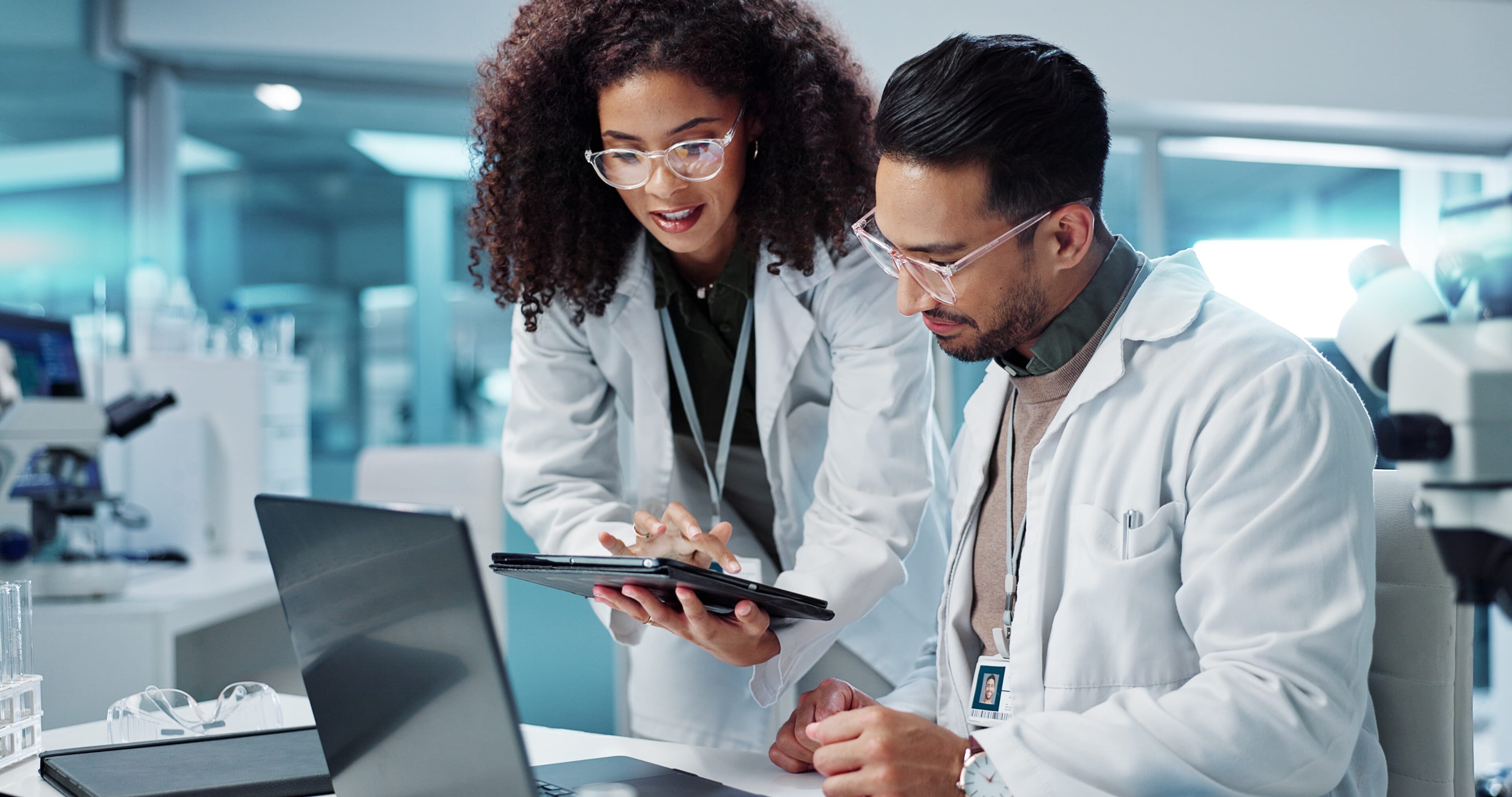 Science, teamwork and scientist with tablet in laboratory for communication, pharmaceutical review or planning. Employees, collaboration and technology for research, discussion and digital analysis.